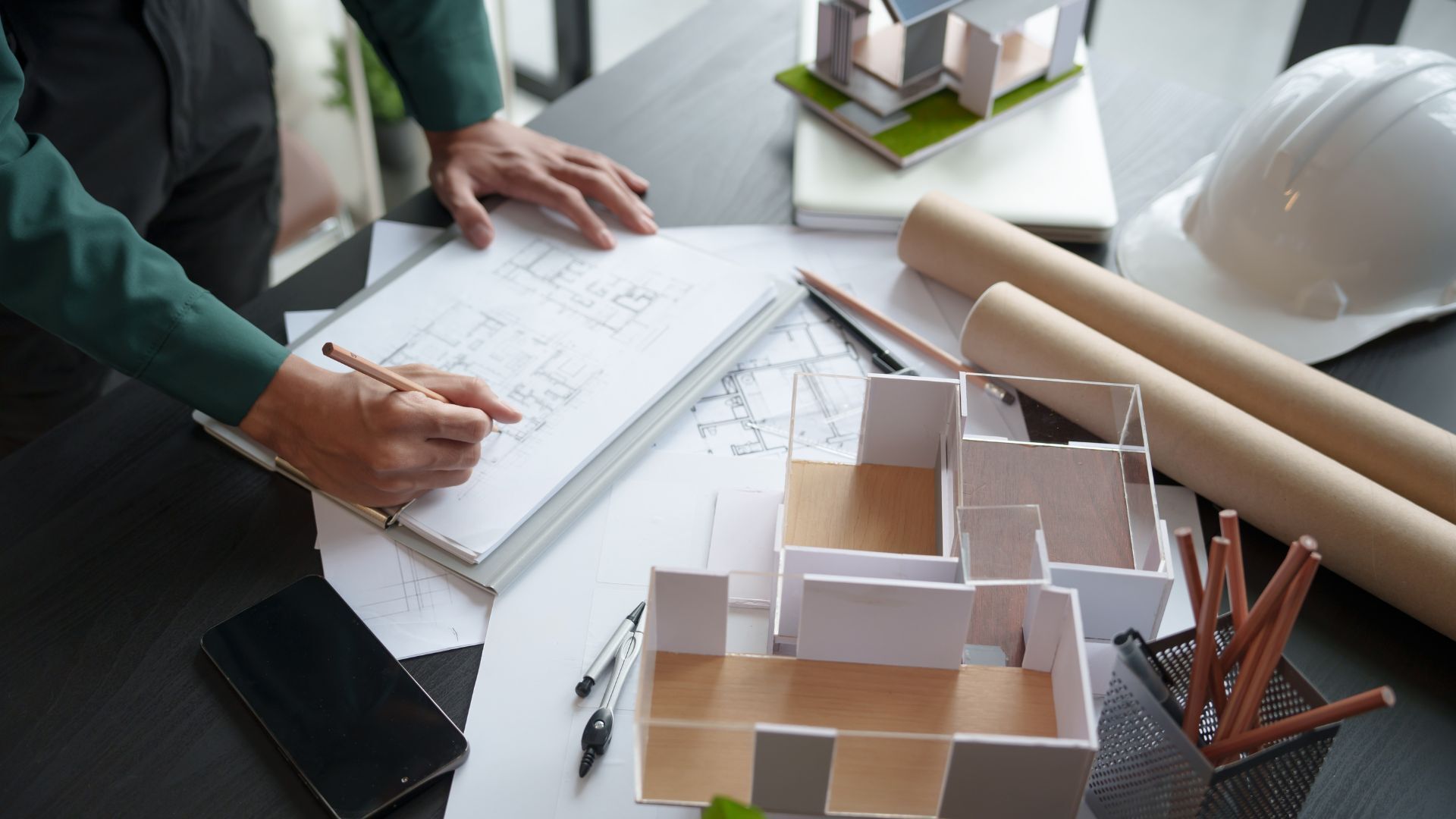 Architect drawing up architectural plans on a desk