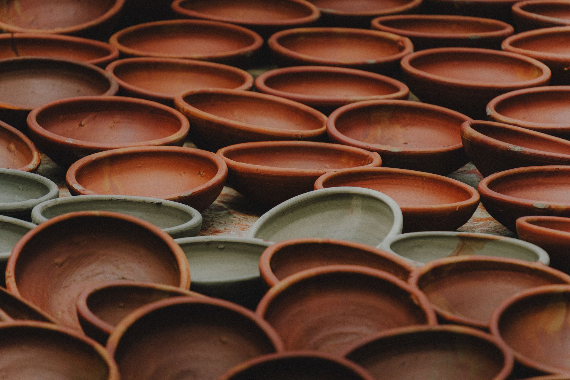 A close-up view of handcrafted clay pots in earthy red and gray tones, showcasing traditional pottery art. Credit: Soumyojit Sinha